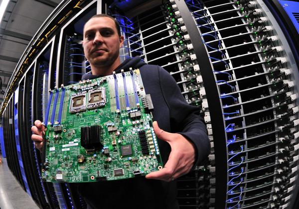 Rows of glowing server racks in a large data center at night, illustrating the global demand for AI computing power
