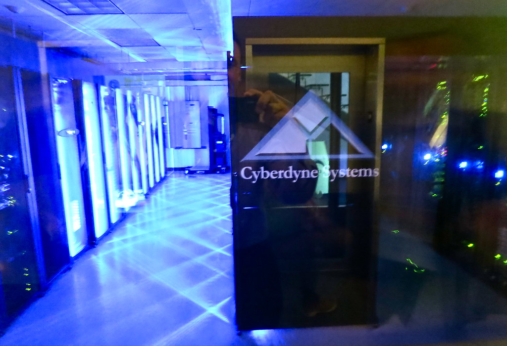 Rows of glowing server racks in a dim data center at night, symbolizing the hidden complexity behind AI systems