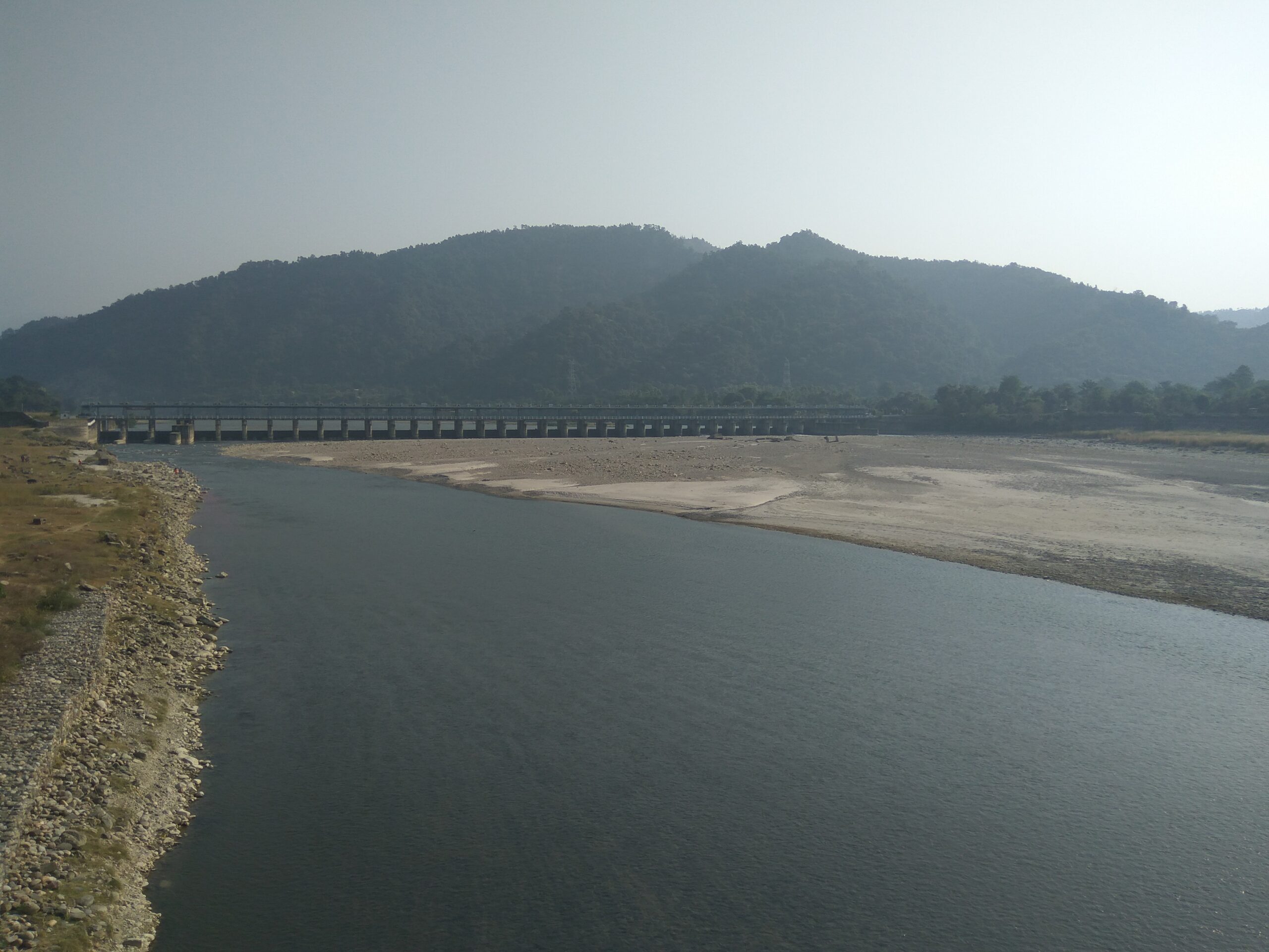 A river flowing through farmland with irrigation canals feeding fields on both banks